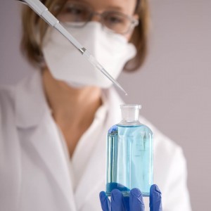 lab technician taking sample of blue liquid