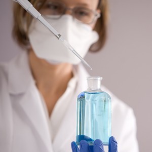 Lab technician with blue liquid sample